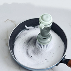 Soap dispensing dish brush mint green scrubbing pan with foam close up