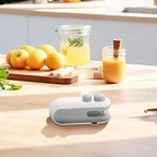 Portable mini sealing machine on kitchen counter with fresh fruits and juice